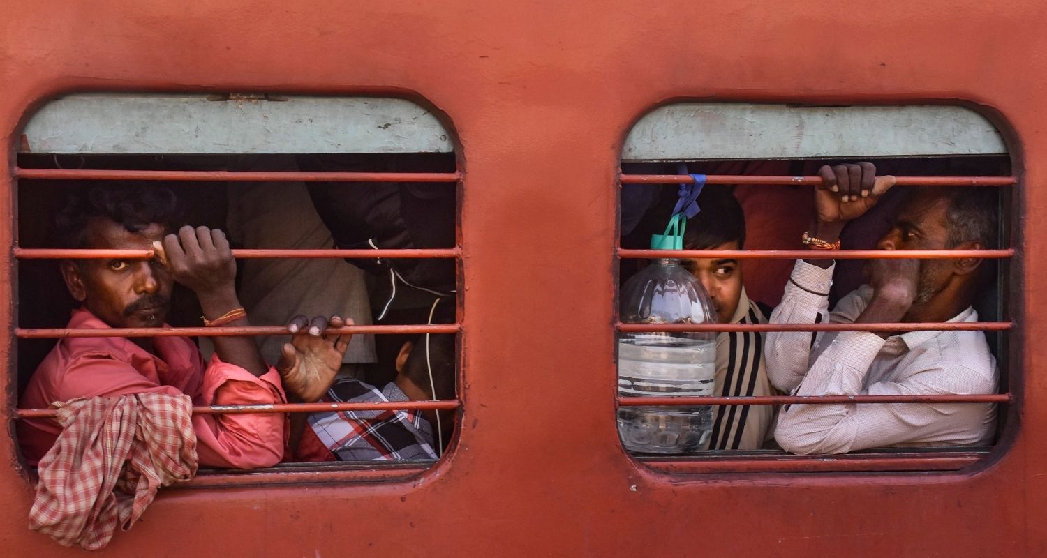 Passengers ride an overcrowded train ahead of the 'Chhath Puja' festival, at a railway station in Moradabad, UP, Thursday.